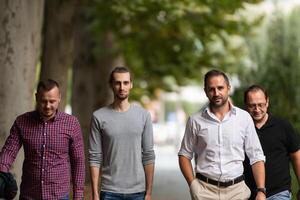 After a productive day at work, a group of diverse colleagues enjoy a leisurely stroll through a modern and natural urban setting photo