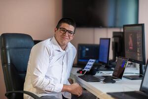 A programmer diligently testing smartphone applications while sitting in their office. photo
