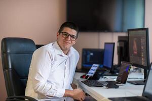 A programmer diligently testing smartphone applications while sitting in their office. photo