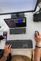 Top view of programmer diligently testing smartphone applications while sitting in their office. photo