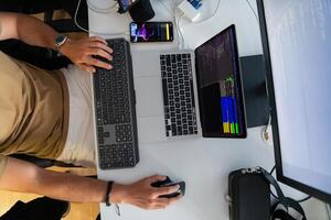 Top view of programmer diligently testing smartphone applications while sitting in their office. photo