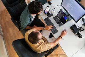 Top view of programmer diligently testing smartphone applications while sitting in their office. photo