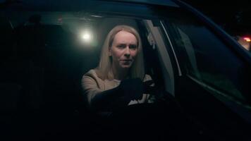 Nervous worried anxious Caucasian woman female lady girl driver sitting inside automobile driving car steering wheel looking mirror dark road darkness drive danger at city street evening late night video