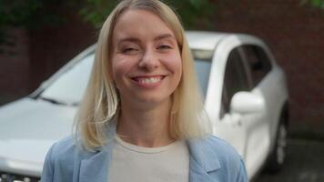 Positive joyful Caucasian woman auto owner looking at camera driver smile girl demonstrating thumb up gesture female businesswoman feeling happy with new car automobile purchase vehicle rent in city video