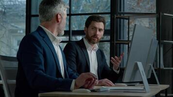 Executive businessmen Caucasian men partners professional business people working on computer in office discussing project planning development on Internet work together discuss financial market data video