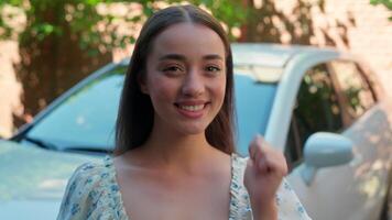 Happy smiling glad Caucasian woman female girl car owner driver buyer looking at camera pointing thumb finger showing automobile holding auto vehicle keys excited shouting rejoice new purchase at city video