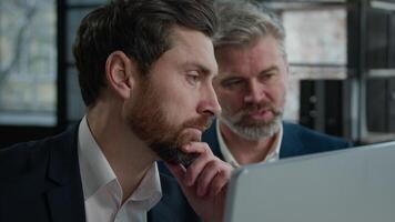 Close-up Caucasian men businessmen looking at computer screen in office executive businessman tell explain male colleague client investor sharing business news advice software explaining digital data video