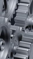 A close-up perspective showcases a series of rotating interlocking metal gears, highlighting the precise engineering and the complexity of mechanical design in machinery. vertical footage video