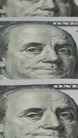 Detailed portrayal of Benjamin Franklin's face from a hundred-dollar bill, showcasing the fine engravings and textures of the currency in a controlled indoor setting. video