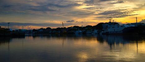 A boat is docked at a dock at sunset photo
