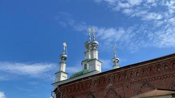 Beautiful view of church with green domes. Clip. Circle around beautiful white church with domes on background sky. Timelapse of church review on background of blue sunny sky with clouds video