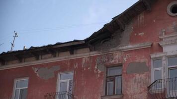 Old residential building. Clip. Close-up view of shabby facade of old residential building. Crumbling facade of old apartment building on background sky video