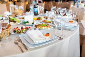 Elegant Dining Setup With Assorted Dishes and Drinks at a Banquet Hall During Evening Event photo