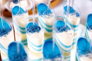 Colorful Layered Dessert Shots With Blue Topping at a Festive Event Table Setting photo