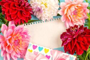 summer background. dahlias and a canvas on a blue wooden background. art. space for a text photo