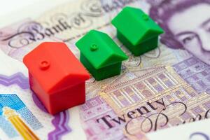 A house model is sitting on top of a twenty pound note photo