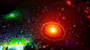 Aerial View of Crowd at Nighttime Gathering Around Bonfire photo
