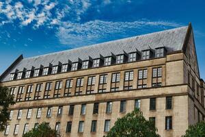 Beige Building with Many Windows and a Dark Gray Roof photo