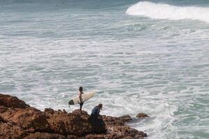 A surfer and bodyboarder about to get in the water at VVF, Anse l'Etang, Tartane, Martinique, West Indies, France photo