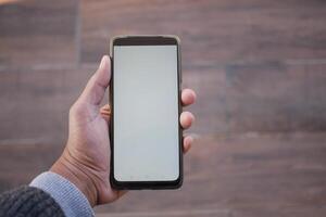 A Person Holding a Smartphone with a Completely Blank Screen for Potential Use or Display photo