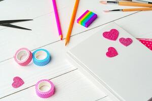 Crafting a colorful workspace with decorations, stationery, and artistic tools on a clean wooden surface photo