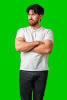 A man with a serious expression stands with crossed arms against a vibrant green background photo
