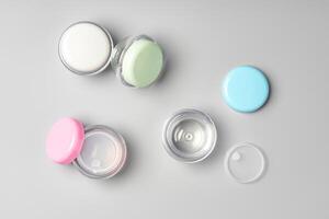 Colorful cosmetic containers arranged neatly on a light gray background photo