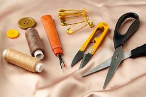Sewing tools and materials arranged on a luxurious golden fabric background in a creative crafting workspace photo