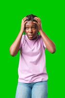 A woman expressing frustration while standing in front of a bright green background photo