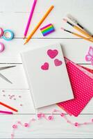 Crafting a colorful workspace with decorations, stationery, and artistic tools on a clean wooden surface photo