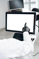 A person in gloves interacting with a touchscreen display in a modern office environment photo