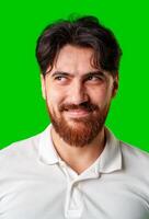 A young man with a beard showing a serious expression against a vibrant green background photo