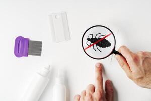 Tools for inspecting and treating lice infestations at home with a magnifying glass and a comb photo