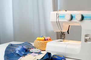 Sewing machine in use on a wooden table, stitching a light fabric in a well-lit indoor workspace photo