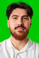 A smiling young man with a beard poses against a bright green background photo