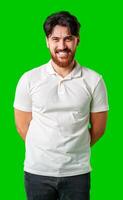 A smiling young man with a beard poses against a bright green background photo