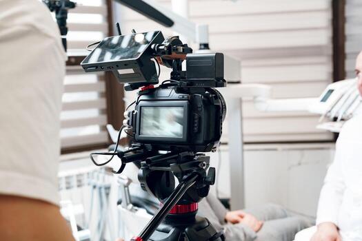 A person operates a handheld gimbal stabilizer with a camera in a modern studio setting during a daytime shoot photo