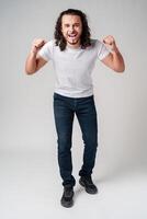 Happy man celebrating success with raised fists in a studio against a plain background photo