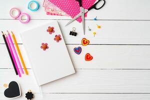 Crafting a colorful workspace with decorations, stationery, and artistic tools on a clean wooden surface photo