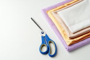 Crafting supplies arranged on a table with scissors and folded fabric in various colors photo