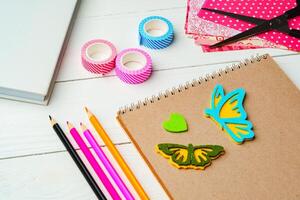 Crafting inspiration with colored pencils, decorative tape, and playful shapes on a rustic wooden surface photo