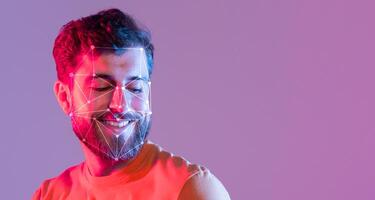 A man wears a bright orange shirt while smiling, captured within a bright purple background. Visual patterns enhance his facial features, showcasing technology and emotion. photo