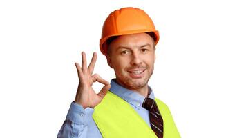 Cheerful Builder In Uniform Gesturing Ok Sign Smiling To Camera Standing On White Studio Background. Construction Worker Approving, Building Is Okay, Advertisement Banner Concept. Panorama photo