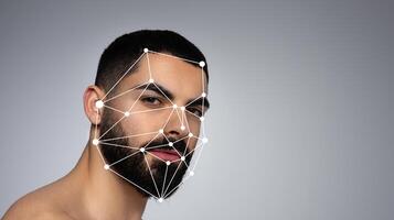 A young man poses with a neutral expression while facial recognition technology overlays points on his face, highlighting his features against a plain background. photo