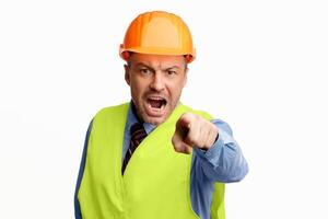 Angry Construction Worker Shouting Pointing Finger Looking At Camera Posing On White Background. Studio Shot photo