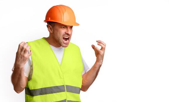 Building Problems Concept. Mad Construction Worker Gesturing Emotionally And Shouting In Anger Posing Standing Over White Studio Background, Looking Aside. Panorama With Blank Space For Text photo