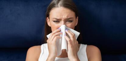 Sick Woman Blowing Nose In Paper Tissue Sitting In Bed During Coronavirus Pandemic Outbreak Quarantine. photo