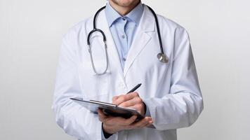 Medical Services Concept. Portrait of smiling male doctor holding clipboard, taking patients history and smiling at camera, light studio background photo