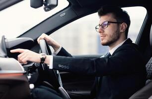Transportation And Destination. Man in glasses searching for route using navigation system on car dashboard screen photo