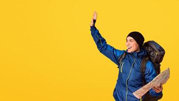Happy backpacker with city map found a place, gesturing over orange background, looking at empty space photo